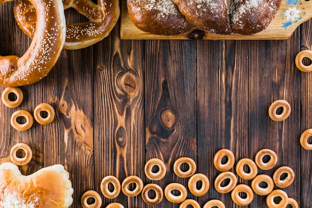 Bagel, pagnotta intrecciata e ciambelline salate sul tavolo di legno