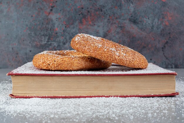 Bagel ricoperti di sesamo su un vassoio ricoperto di polvere di cocco su un tavolo di marmo q.