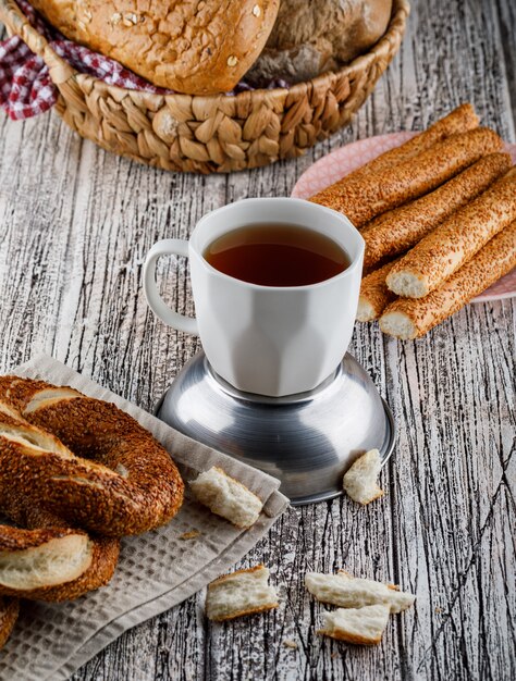 Bagel turco con una tazza di tè su superficie di legno, vista dell'angolo alto.