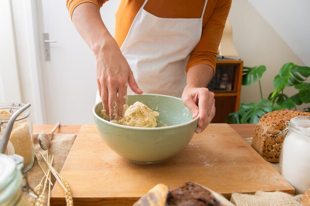 Baker in grembiule impastare per gustosa pasta e pane