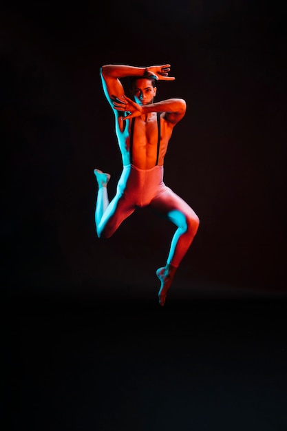 Ballerino di balletto maschio contemporaneo esibendosi sotto i riflettori