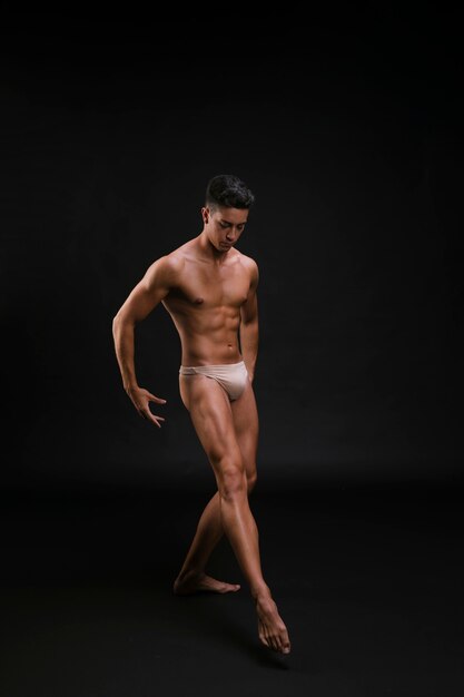 Ballerino di balletto muscolare che allunga con garbo la gamba
