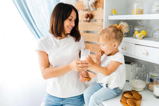 Bambina adorabile che mangia un biscotto