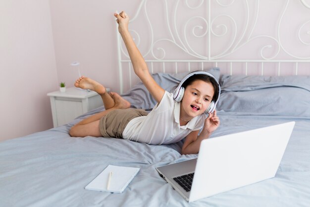 Bambina adorabile che utilizza il suo computer portatile