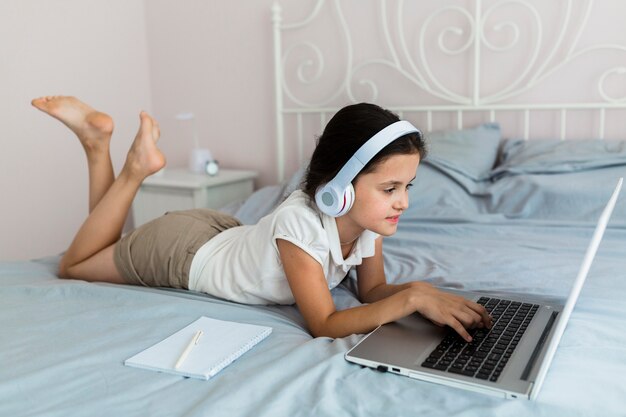 Bambina adorabile che utilizza il suo computer portatile