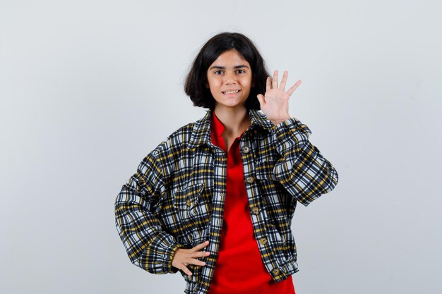 Bambina agitando la mano per il saluto in camicia, vista frontale della giacca.