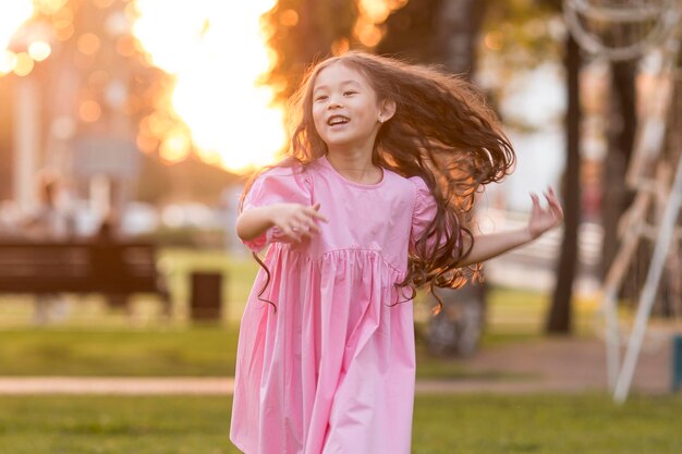 Bambina asiatica di vista frontale con capelli lunghi che funzionano nel parco