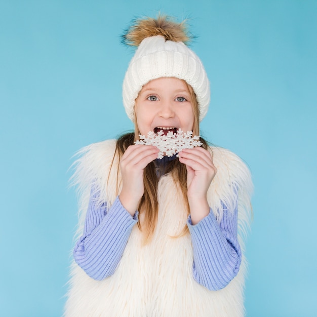 Bambina bionda che mangia un fiocco di neve