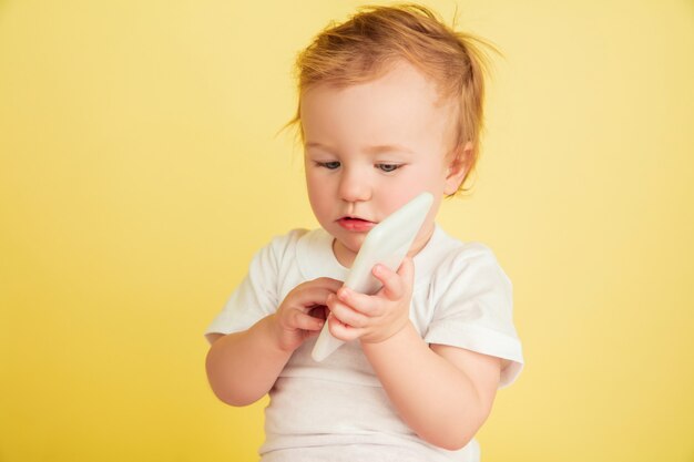 Bambina caucasica, bambini isolati su studio giallo