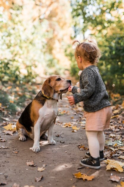 Bambina che alimenta il suo animale domestico nella foresta