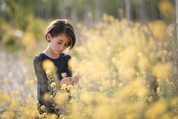 Bambina che cammina nel campo della natura che porta vestito bello