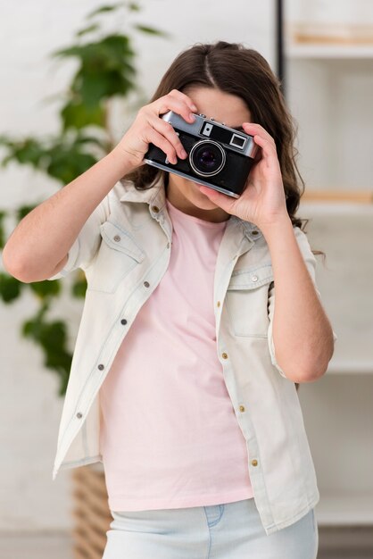 Bambina che cattura una foto con una macchina fotografica