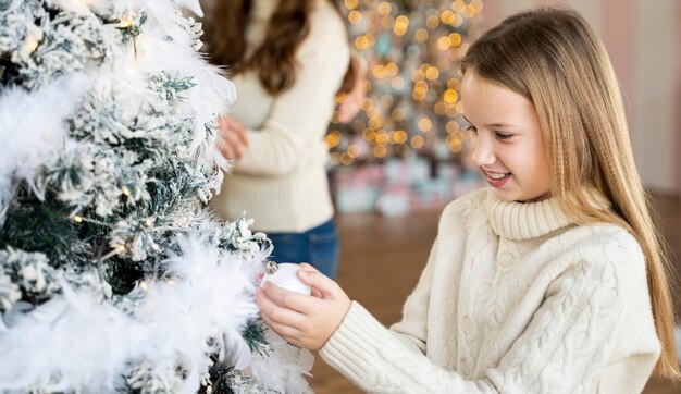 Bambina che decora l'albero di Natale