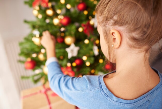 Bambina che decora l'albero di Natale