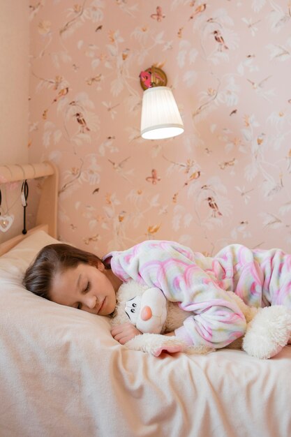 Bambina che dorme con il suo giocattolo preferito a casa