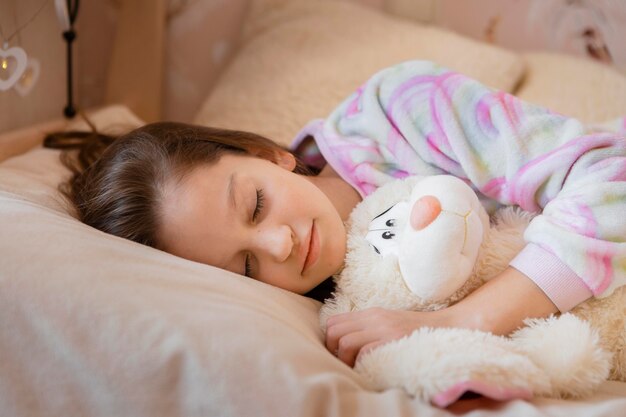 Bambina che dorme con il suo giocattolo preferito