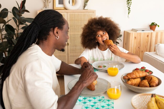 Bambina che fa colazione con suo padre