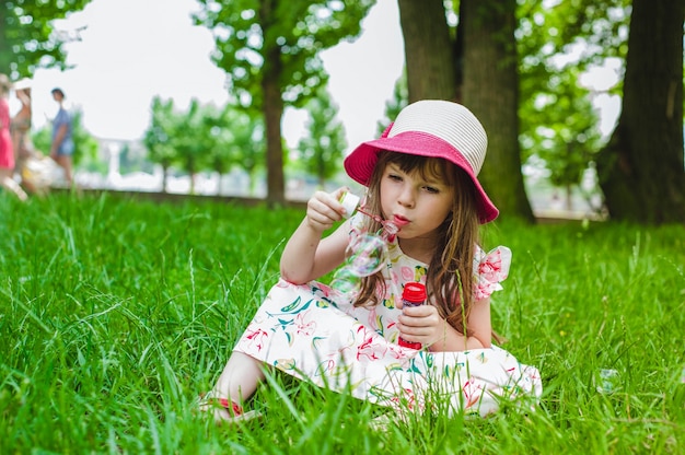 Bambina che fa le bolle con il pomposo