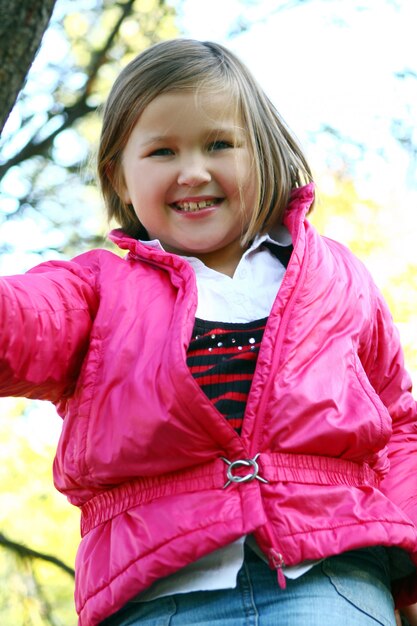 Bambina che fa passeggiata sana attraverso il parco di autunno