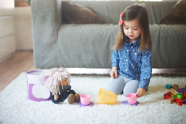 Bambina che gioca con i giocattoli in soggiorno