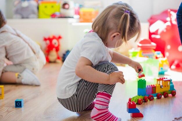 Bambina che gioca con il giocattolo del treno