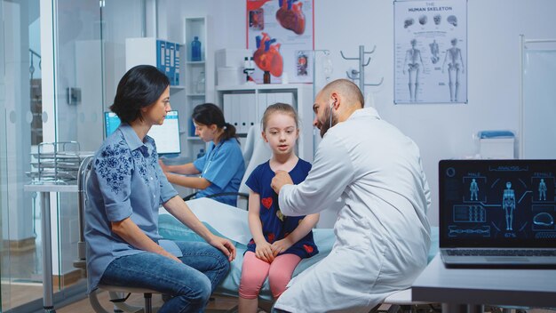 Bambina che ha check-up medico annuale, medico che utilizza uno stetoscopio. Operatore sanitario medico specialista in medicina che fornisce servizi di assistenza sanitaria trattamento di consultazione in ospedale