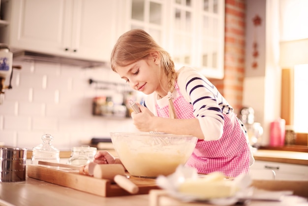 Bambina che impara a fare un impasto corretto