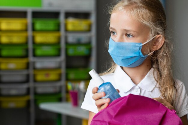 Bambina che indossa una maschera medica con copia spazio