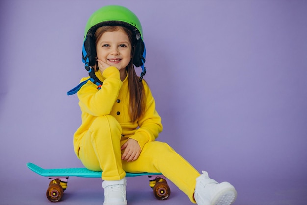 Bambina che insegna a guidare lo skateboard indossando il casco