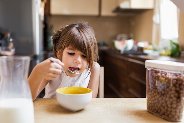 Bambina che mangia prima colazione di mattina