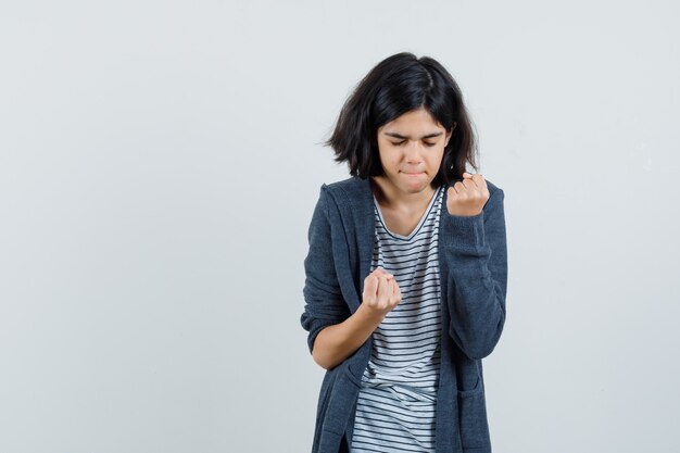 Bambina che mostra il gesto di successo in t-shirt, giacca e sembra felice