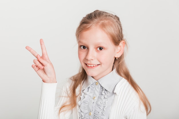 Bambina che mostra il segno di vittoria