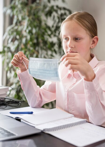 Bambina che partecipa alla lezione online all'interno