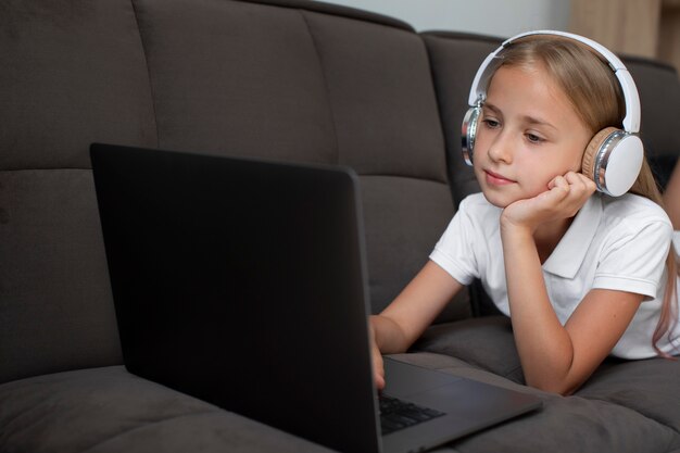 Bambina che partecipa alle lezioni online mentre usa le cuffie