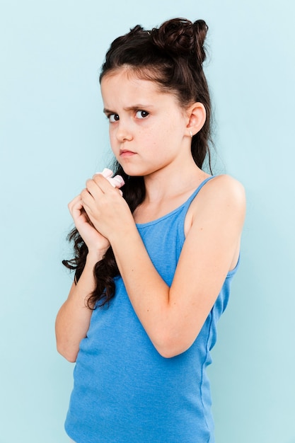 Bambina che prova a nascondere la merenda