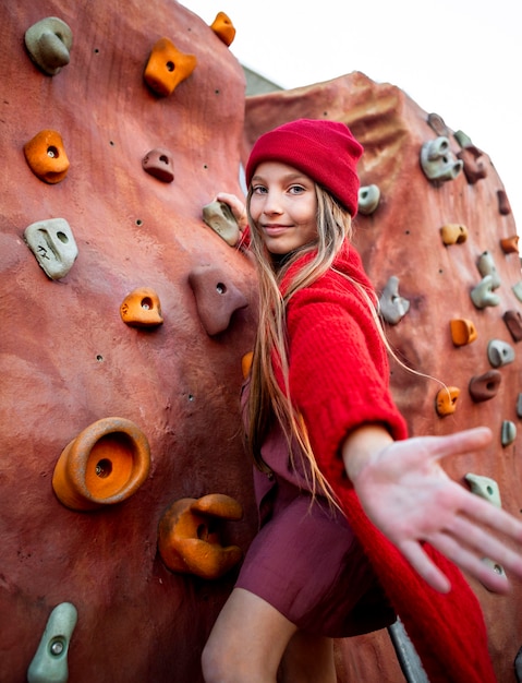 Bambina che prova una parete da arrampicata