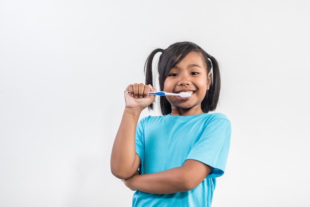 bambina che pulisce i suoi denti nel colpo dello studio