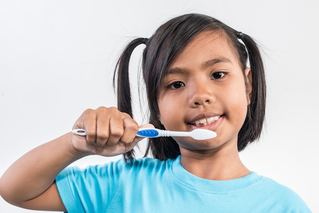 bambina che pulisce i suoi denti nel colpo dello studio