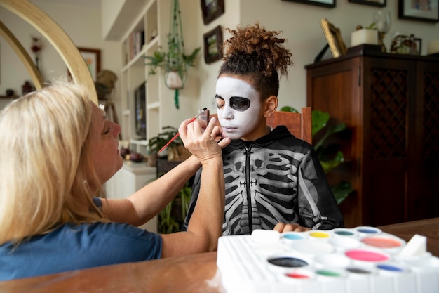 Bambina che si prepara per halloween con un costume da scheletro