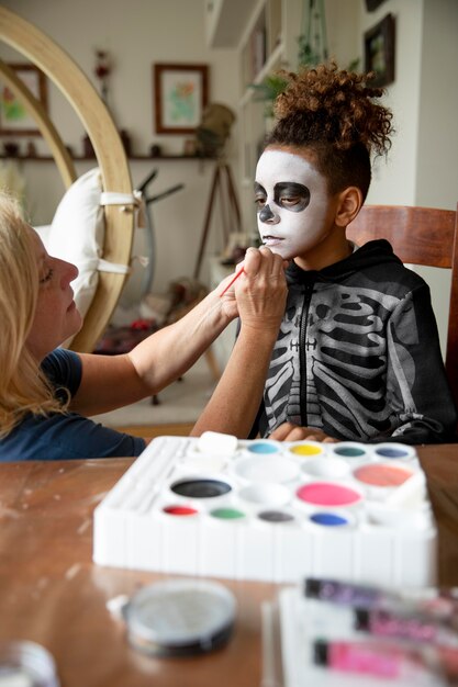 Bambina che si prepara per halloween con un costume da scheletro