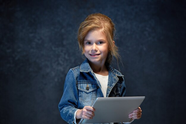 Bambina che si siede con il tablet