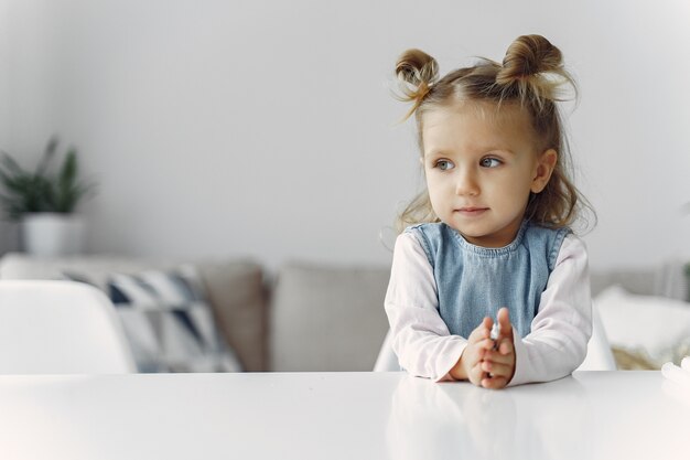 Bambina che si siede su una tabella con il giocattolo