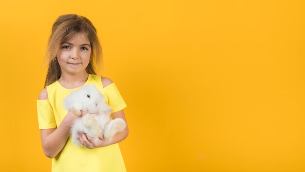 Bambina che tiene coniglio bianco