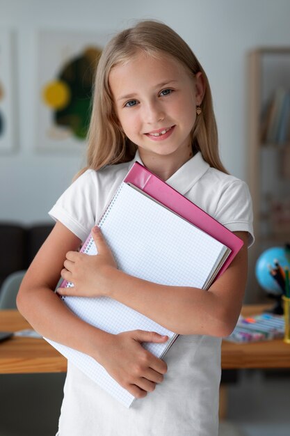 Bambina che tiene i suoi libri