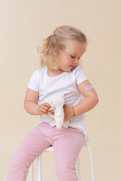 Bambina che tiene in mano un giocattolo dopo aver ricevuto un vaccino