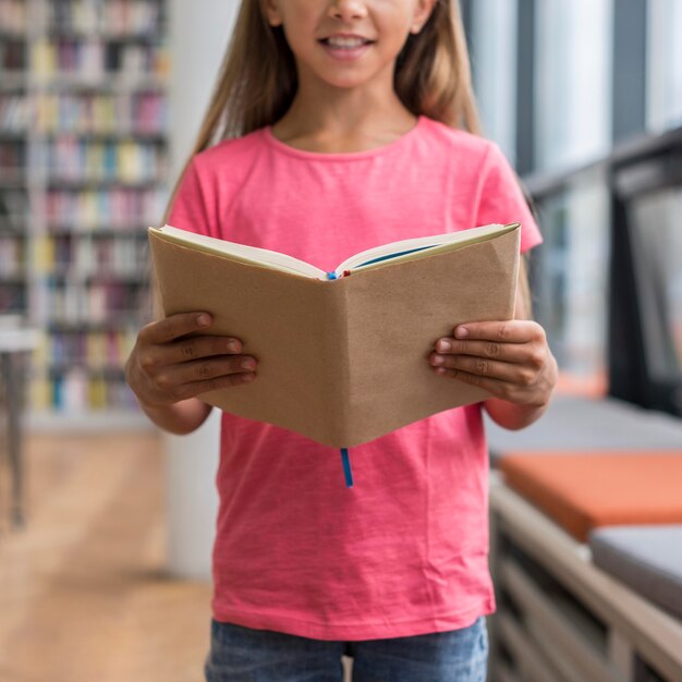 Bambina che tiene un libro aperto