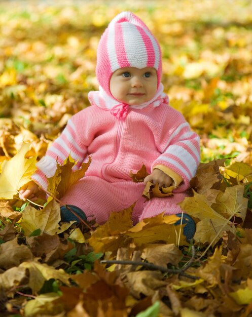 Bambina con foglie d&#39;autunno