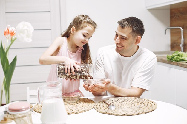 Bambina con i capelli lunghi. Padre e figlia insieme. La famiglia si prepara da mangiare.