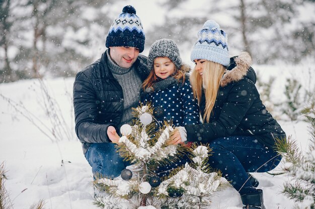 Bambina con i genitori che giocano in un parco d'inverno