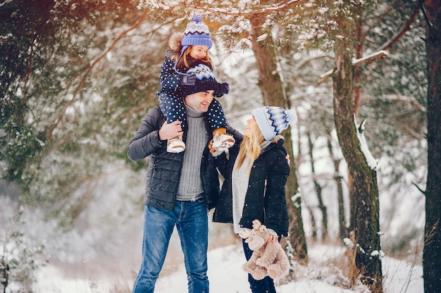 Bambina con i genitori che giocano in un parco d'inverno